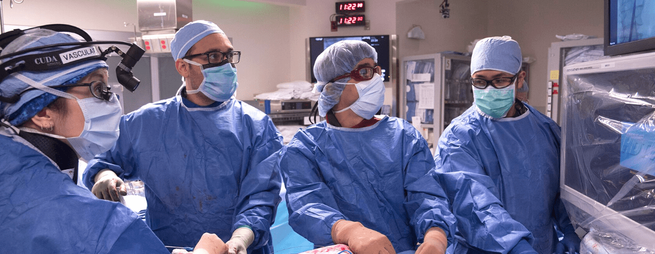 Image: Vascular surgeons looking at a computer screen during an operation. 