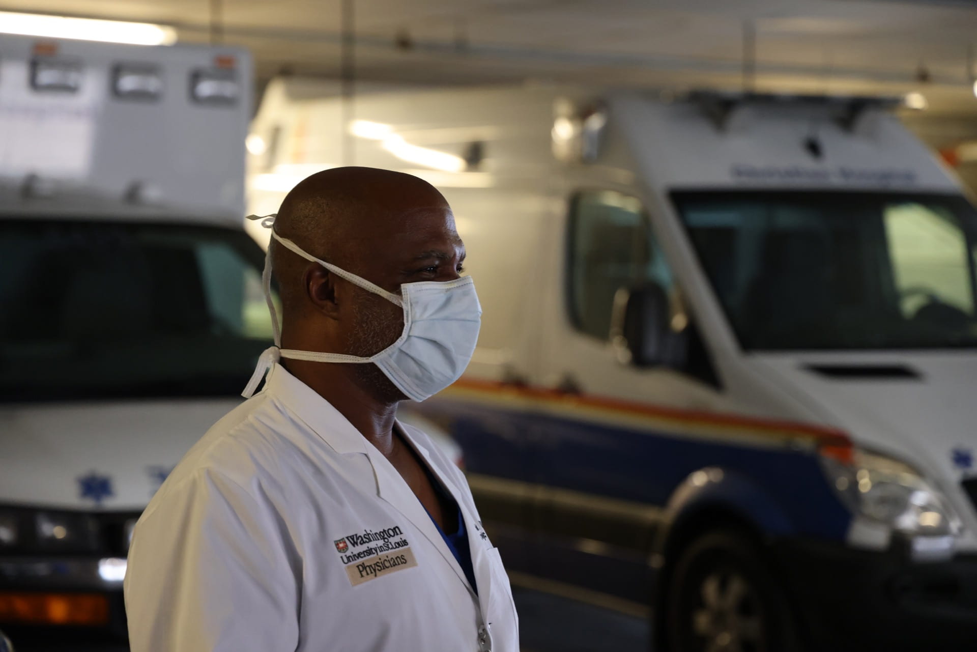 Urologist Arnold Bullock standing in front of ambulances outside of Christian Hospital.