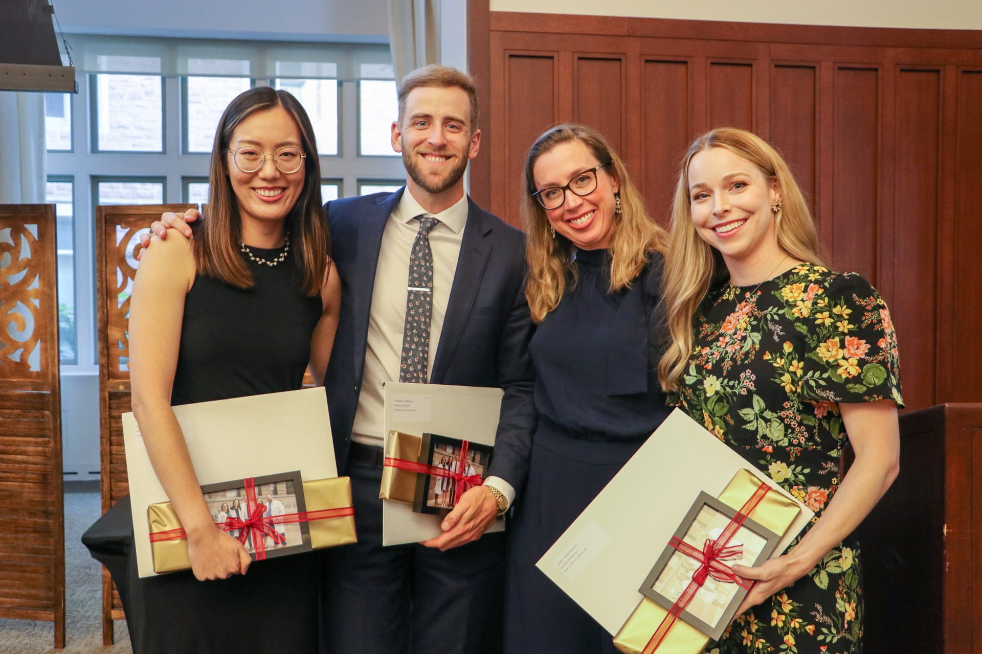 Urology graduates Meng, Parker and Rostrom with program director Traxel and gifts