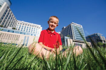 Patient, Noah Hingst, sitting in front of Barnes-Jewish Hospital.