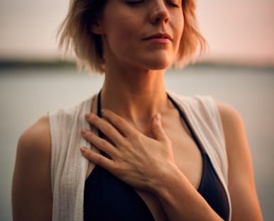 Photo of a woman with a hand to her chest.