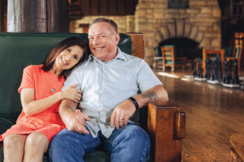 Recovered lung cancer patient and wife seated in home smiling