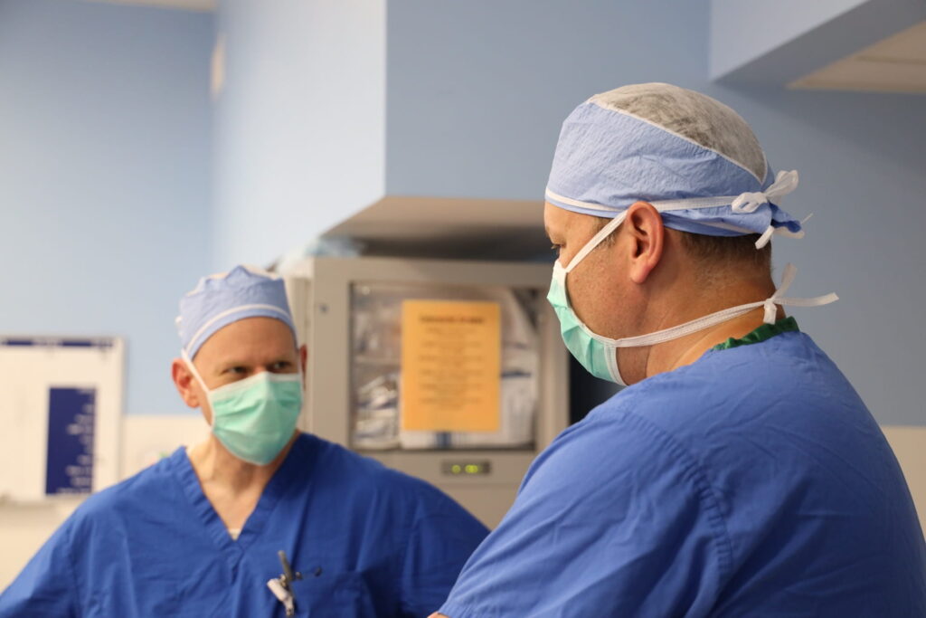 Doctors Wise and Glasgow conversing in operating room