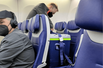A Southwest Airlines employee attaches a seatbelt to a cooler containing lungs to be transplanted, on Friday, Jan. 28, 2022.
