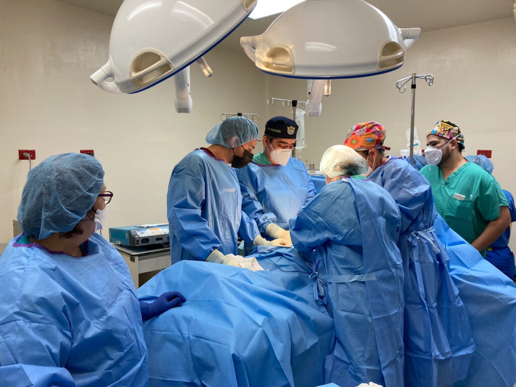 Surgical team in blue scrubs operating in El Salvador hospital