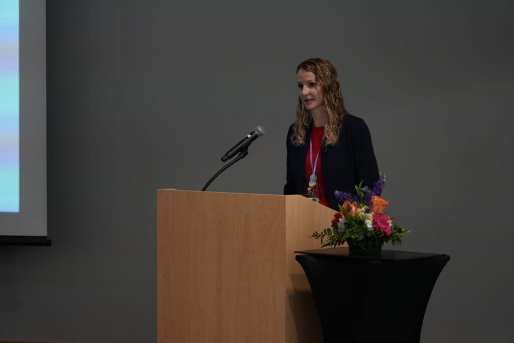 Plastic surgeon Alison Snyder-Warwick at podium with microphone and flowers
