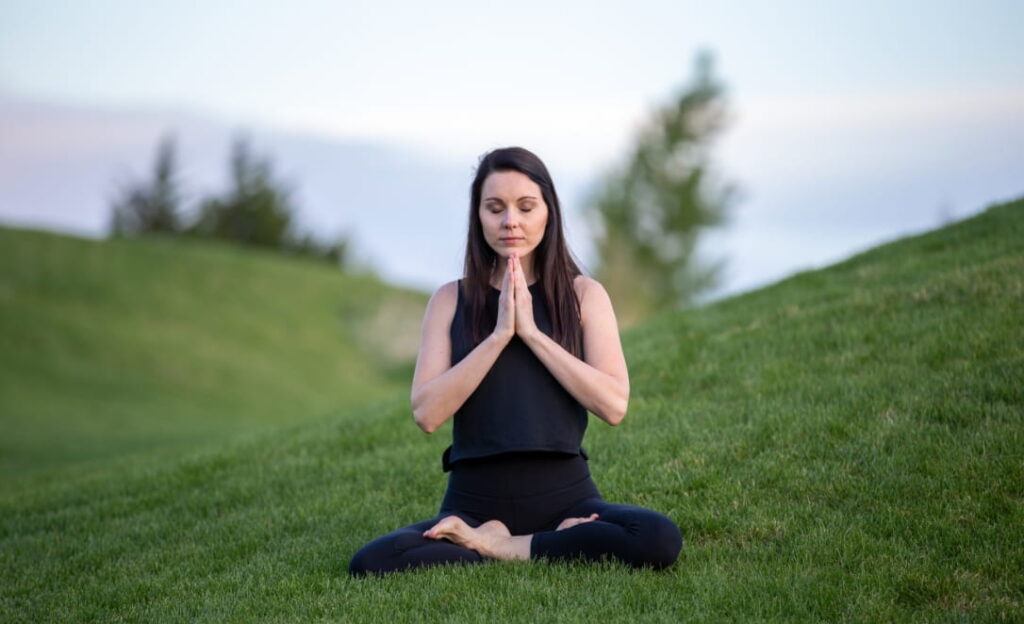 Photo of a person seated in a Yoga position.