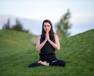 Photo of a person seated in a Yoga position.